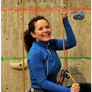 Femme qui fait de l'escalade sur un mur synthétique